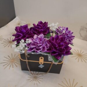 Flower box w czarnej torebce z fioletowymi kwiatami